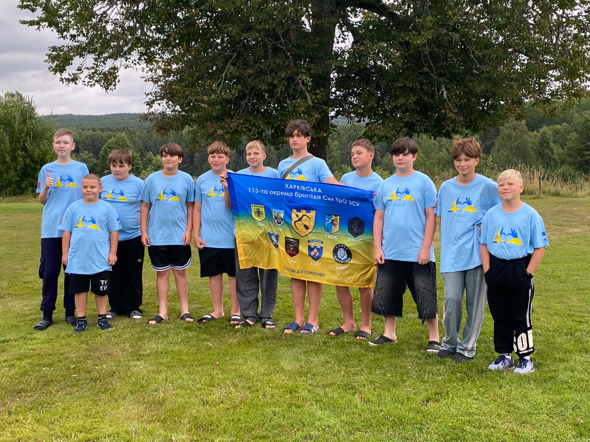 De ukrainska ungdomarna med Korsun-Shevchenkivskyis flagga och t-shirtar om vänortssamarbetet med Sunne.