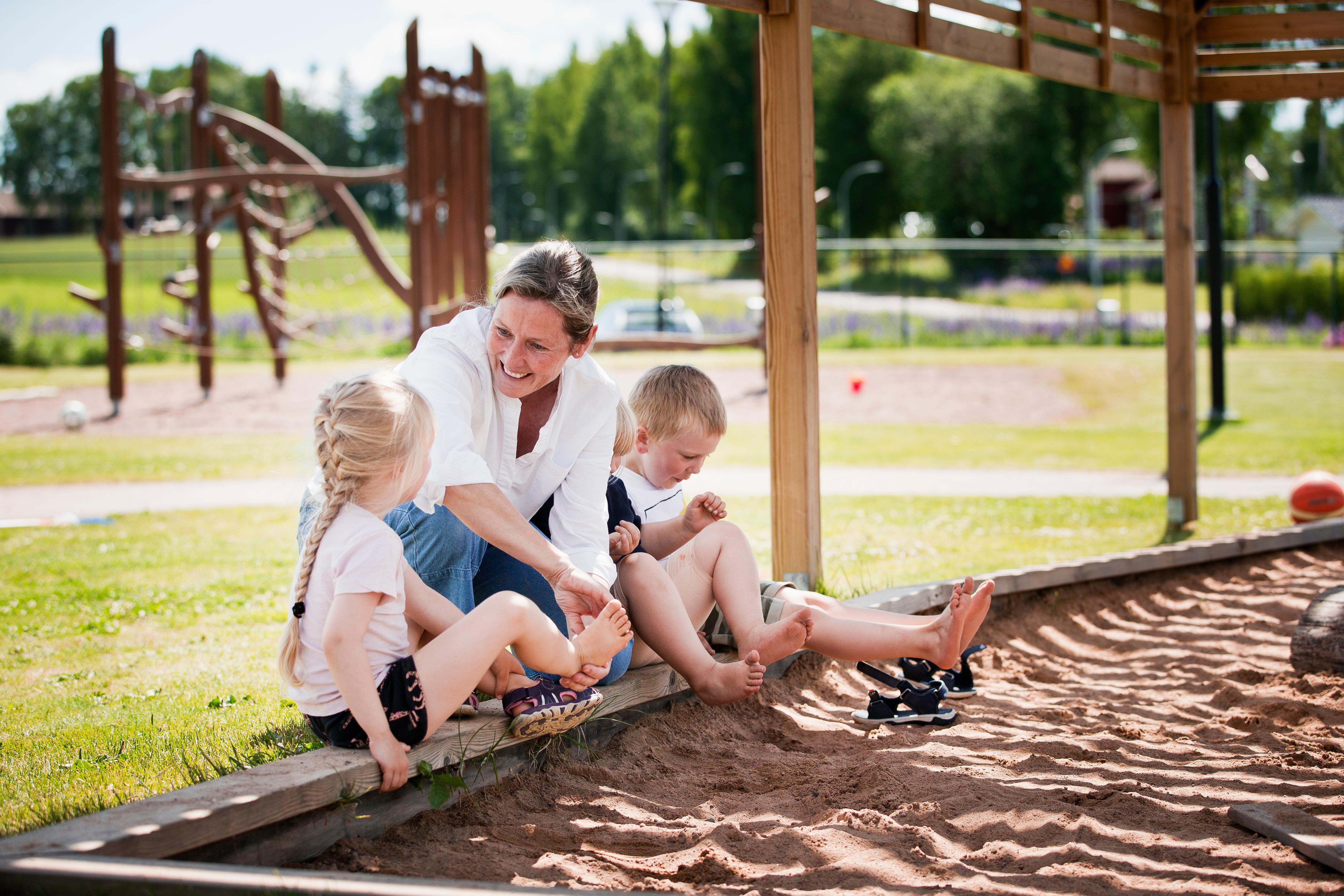 Förskolelärare tillsammans med två barn.