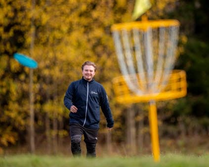 Bild på person som spelar discgolf