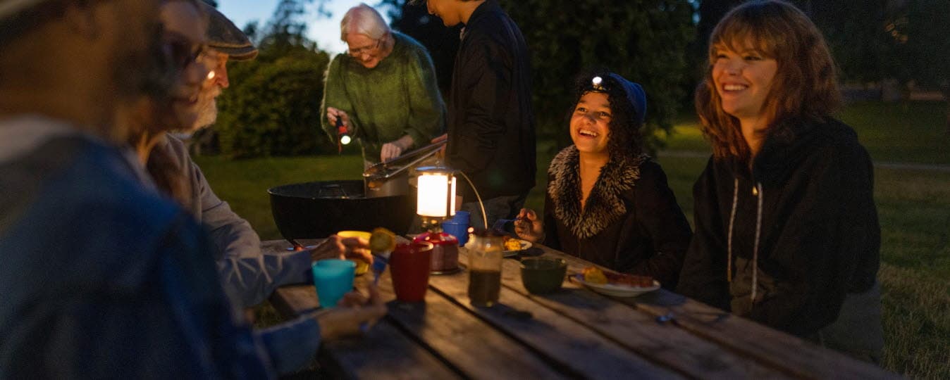 Grannar grillar och umgås utomhus under strömavbrott.