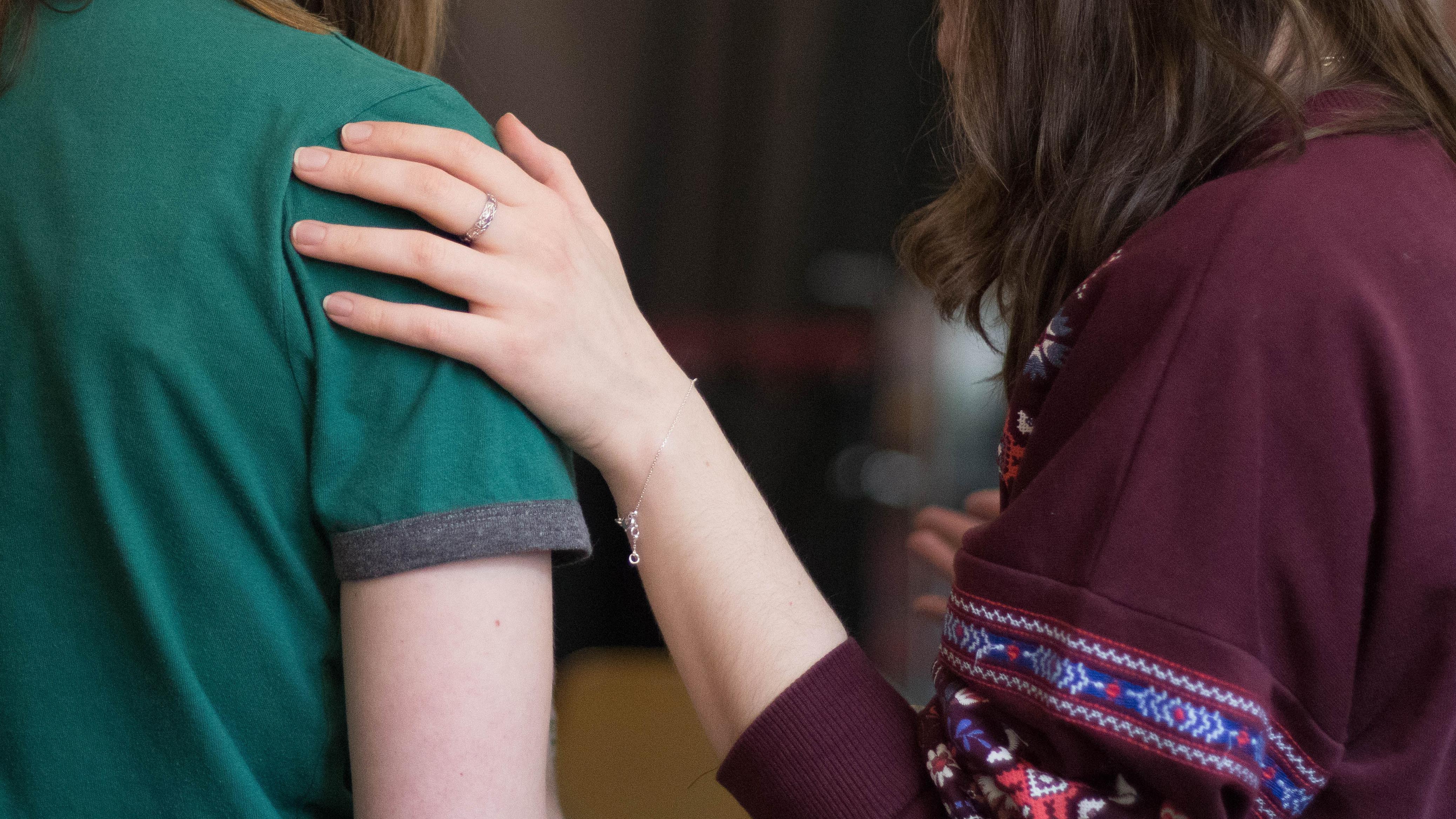 En stöttande hand på en axel.