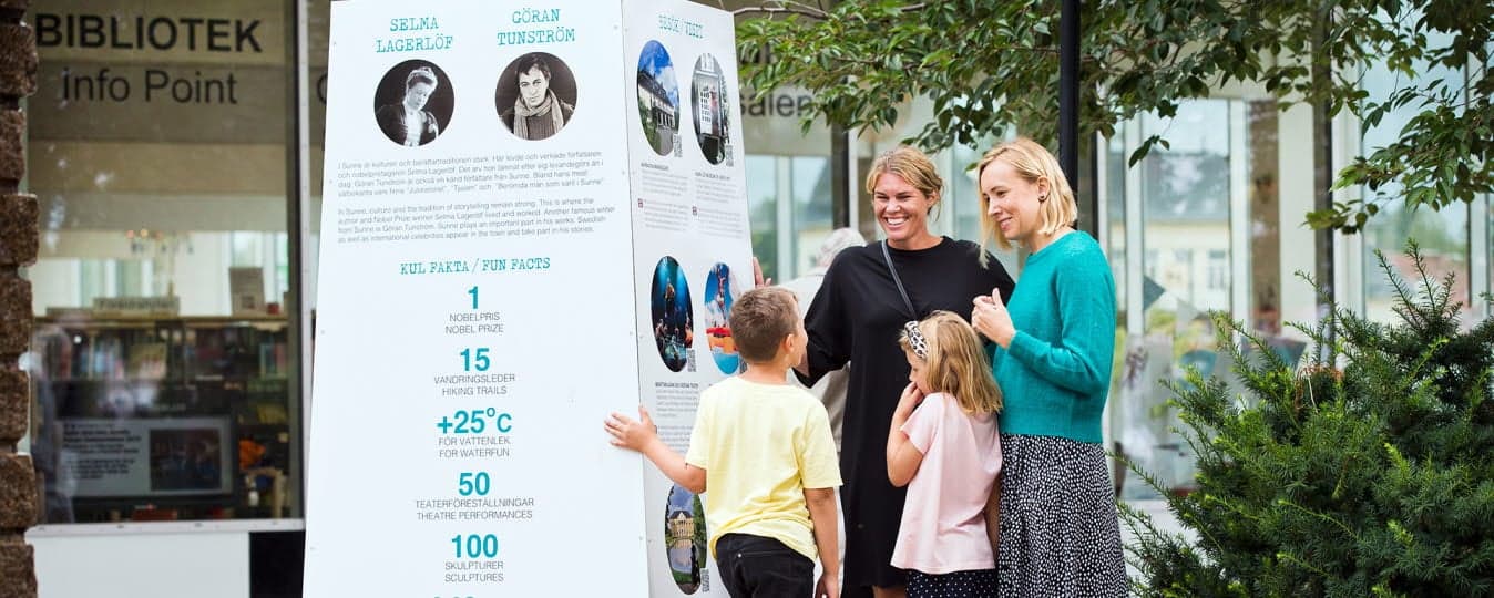 Bild på en familj vid turistinformationen utanför Sunne bibliotek