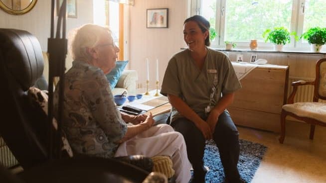 Sjuksköterska på besök hemma hos en senior.