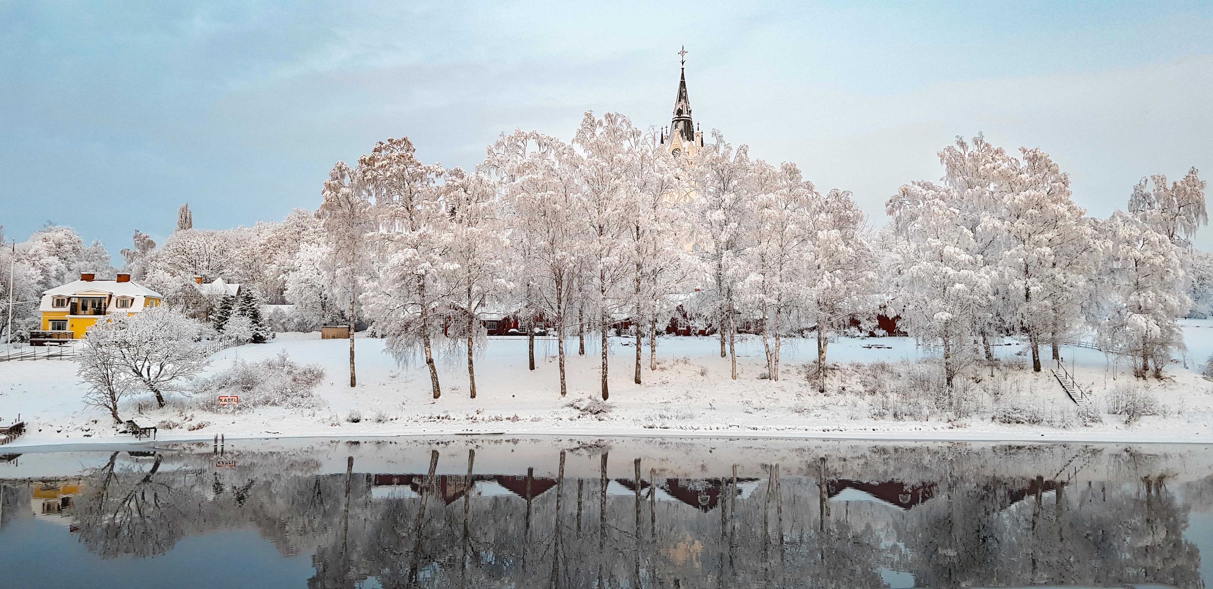 Sunne i vinterlandskap men kyrkan i bakgrunden
