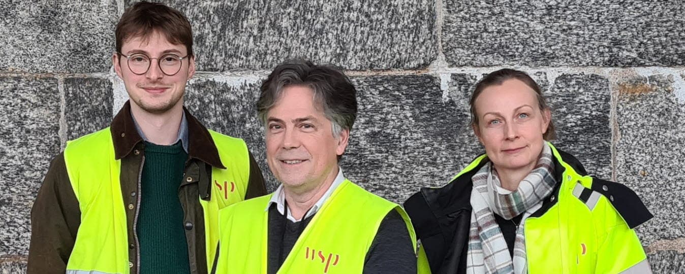 Hugo Nyman, bebyggelseantikvarie, Ezequiel Pinto-Guillaume, arkeolog och Charlotte Hedenström, bebyggelseantikvarie, från konsultföretaget WSP, utför inventeringen. De har varseljacka eller varselväst på sig så att de syns väl.