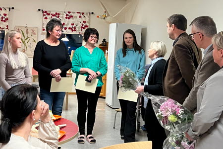 Kommunledningen delar ut blommor till förskolelärarna.